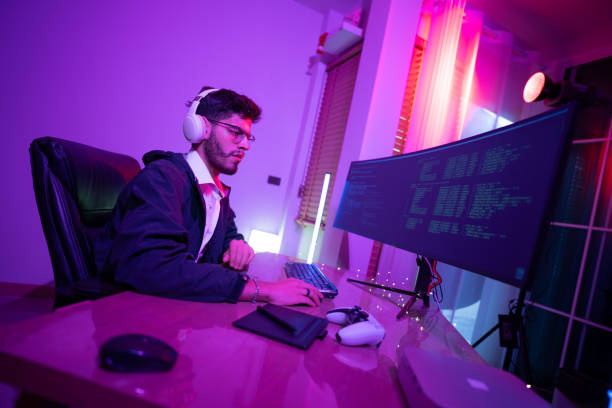 istock Young man working on computer at a stylish desk in a modern room with vibrant lighting 2192813235