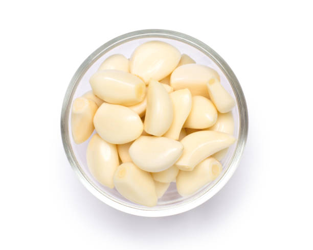 Peeled garlic cloves on white.