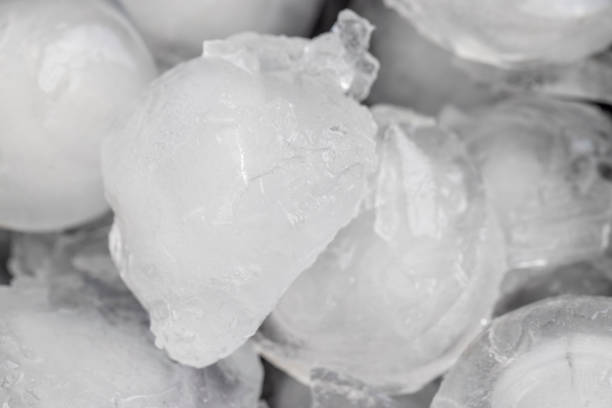 pieces of ice in the water during melting, melting ice in a black bowl