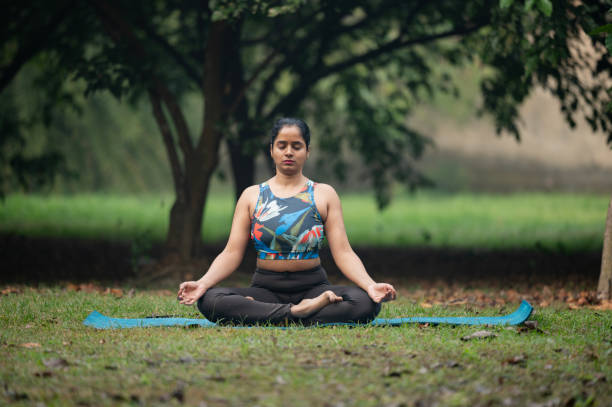 istock Beautiful woman meditating at park 2192815357
