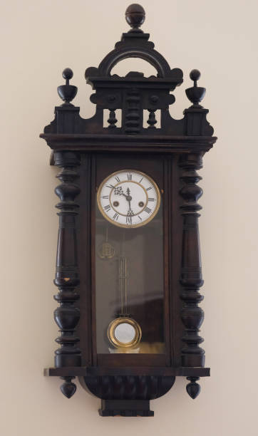 istock vintage clock with a pendulum hangs on a beige wall 2192819119