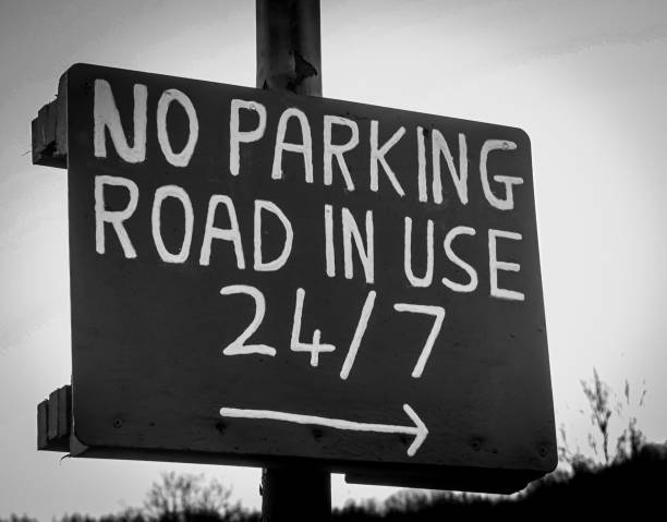 istock Weathered, hand-painted sign warning drivers, 'NO PARKING ROAD IN USE' 2192825099