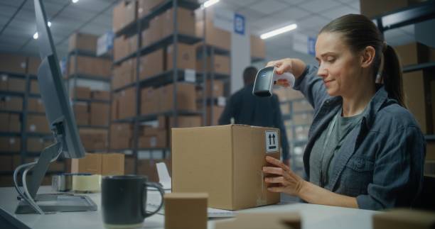 istock Female inventory manager scans parcel with barcode scanner, prepares for shipping to customer 2192827680