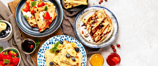 istock Sweet crepes assortment with berries chocolate on gray background. 2192828329