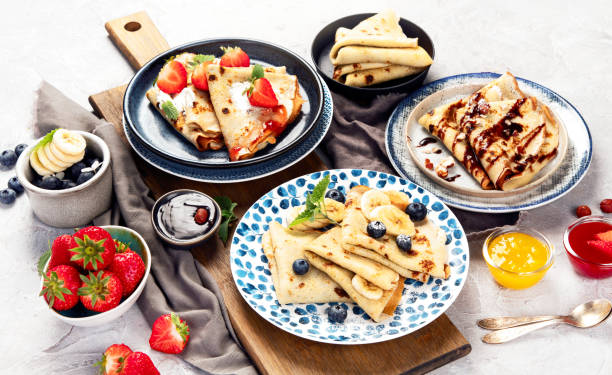 istock Sweet crepes assortment with berries chocolate on gray background. 2192828333