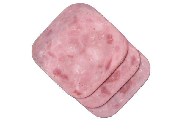 Boiled ham with salt and spices cut into slices on a white background