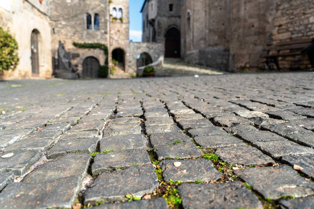 Ground-level view of the cobblestone pavement of a street at the foot of an ancient medieval cathedral
