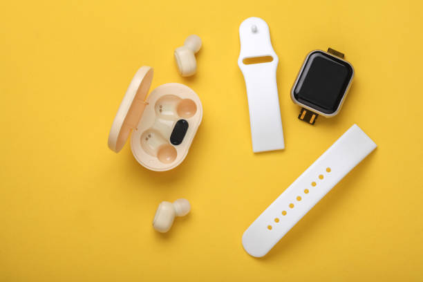 istock Wireless Earphones with Charging Case, smart watch on yellow background. Modern gadgets 2192836969