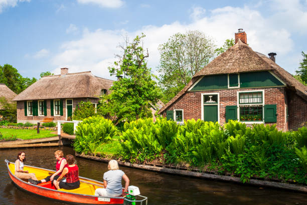 Giethoor, The Netherlands. May 18th, 2007: Sailing through the Giethoorn canals with picturesque houses on small islands and narrow wooden bridges in Giethoorn.