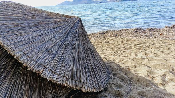istock Seaside. Old wicker parasols lying on the sand. 2192839626