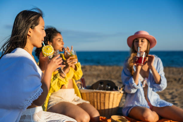 istock Multiethnic girlfriends drinking cocktails at beach picnic 2192840717