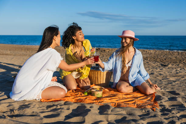 istock Multiethnic girlfriends toasting with healthy drinks at beach picnic 2192840815