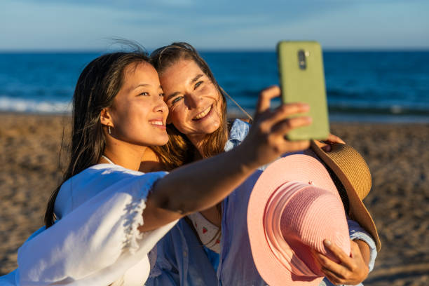 istock Two young women taking a selfie on the beach at sunset 2192841065