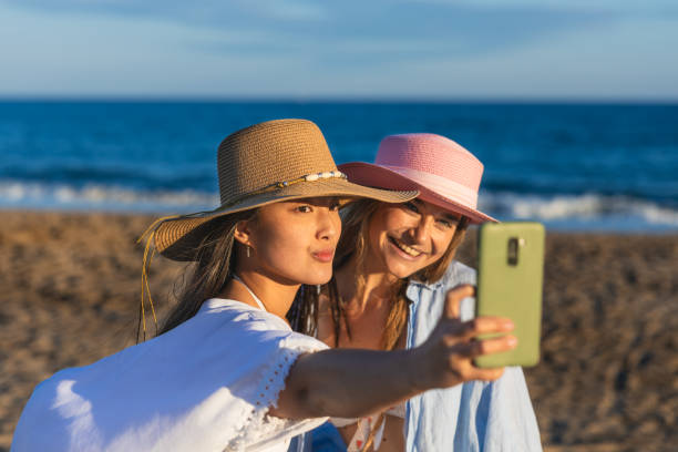 istock Two young women taking a selfie on the beach at sunset 2192841098