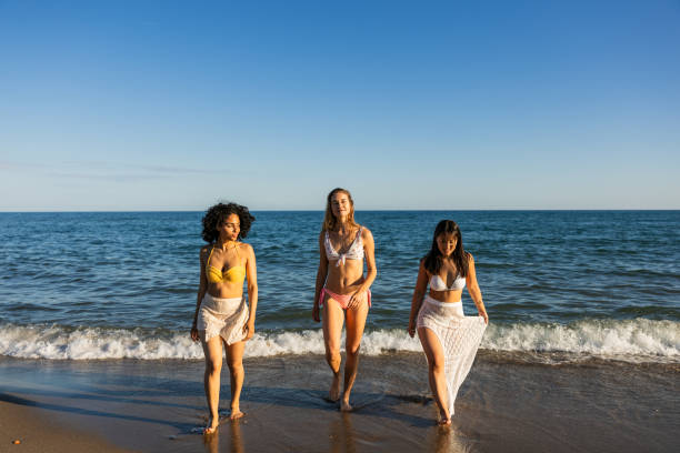 istock Multiethnic young women walking on the beach 2192841749