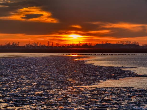 istock Sunset over Frozen Lake and Wind Turbines 2192843689