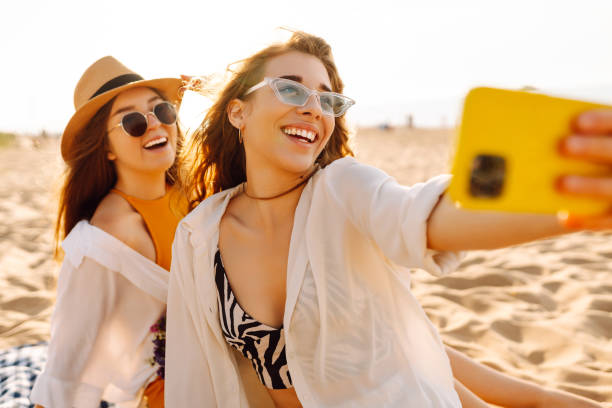 istock Two young beautiful smiling women on beach taking selfie. 2192849880