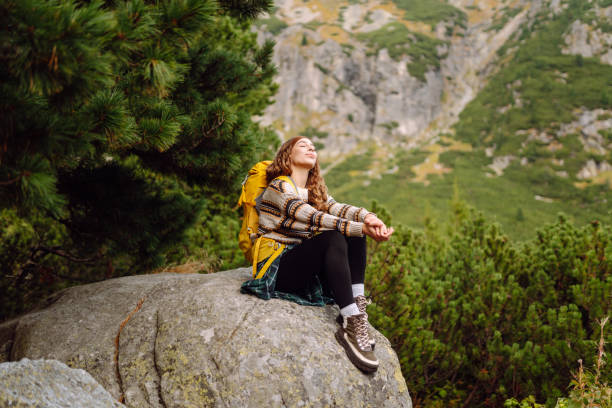 istock Traveler woman is walking down a rocky path with a backpack. 2192852224