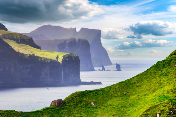 Risin og Kellingin rock formations on the coast of Streymoy Island view from Kalsoy Island, Faroe Islands, Denmark. stock photo