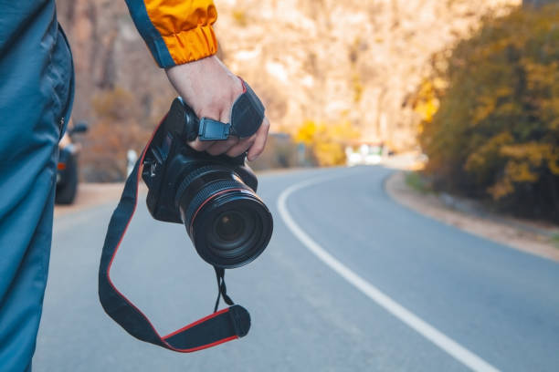 photographer taking photo with camera on the mountain background