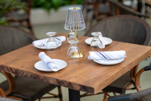 istock Crockery and napkin on table in restaurant. Ceramic empty plates for serving. Dinnerware set for serving luxury dishes. Table setting. Set of clean tableware on wooden table 2192858204
