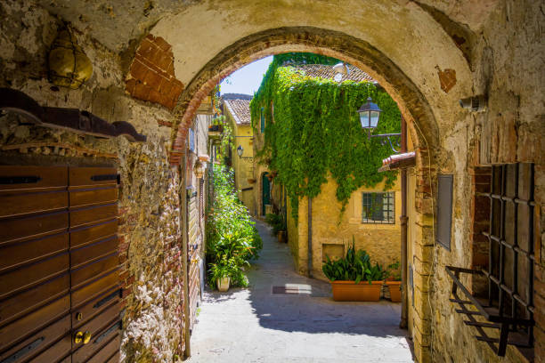 Exploring the charming streets of capalbio, italy, under a brick archway