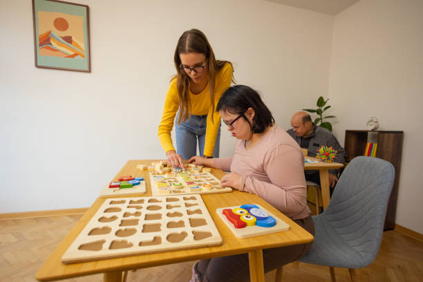 istock Woman with Down Syndrome Arranging Toys with Support 2192862189