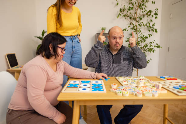 istock Adults with Down Syndrome and Assistant Playing Together 2192864045