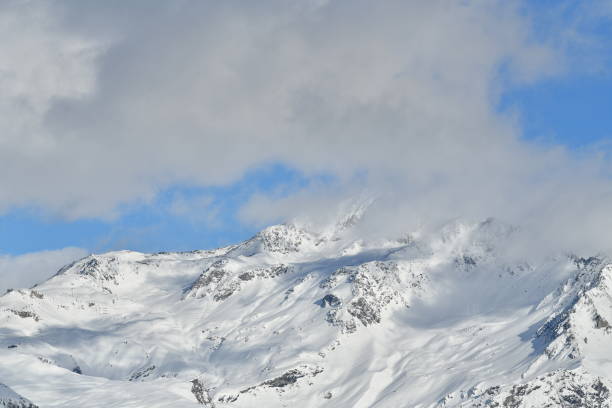 Snowcapped French alps by winter under clouds