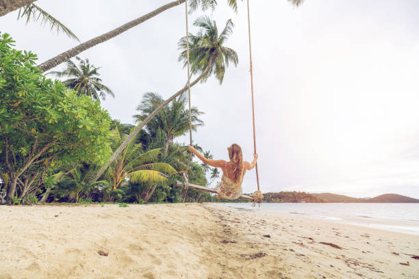 istock Woman Relaxing on Tropical Beach Swing at Sunrise 2192864496