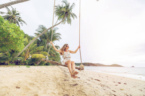 istock Woman Relaxing on a Beach Swing Under Palm Trees 2192865122