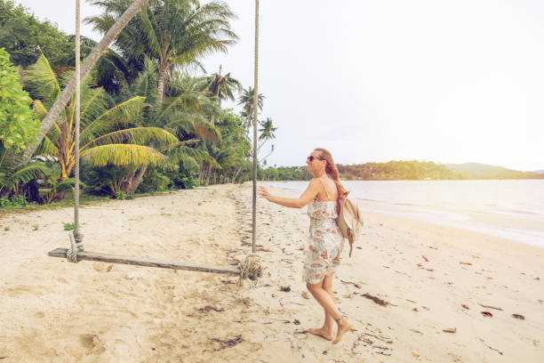 istock Woman Enjoying a Tropical Beach Swing at Sunset 2192865246