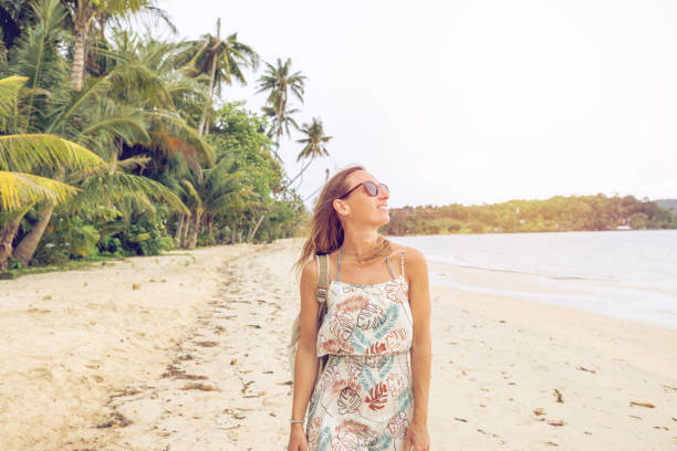 istock Woman Strolling on Tropical Beach in Sunlit Dress 2192865505