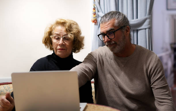 istock a son teaches his mother how to use the computer 2192865873