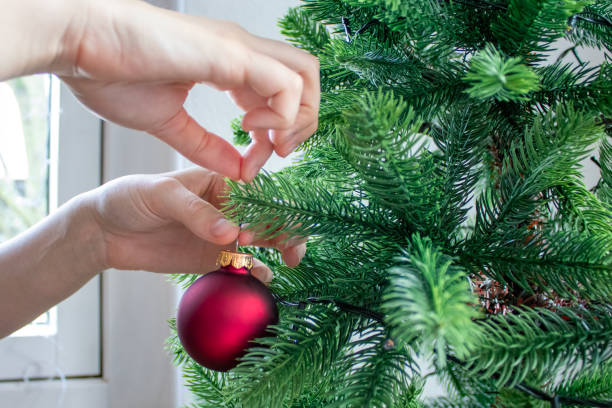 istock Decorating a Christmas Tree With a Red Ornament in a Cozy Indoor Setting During the Holiday Season 2192865875