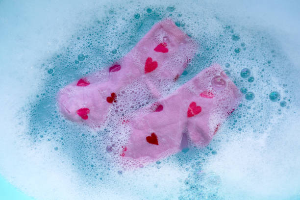 istock Dirty socks soaked in water, dissolving detergent in blue basin. 2192869874