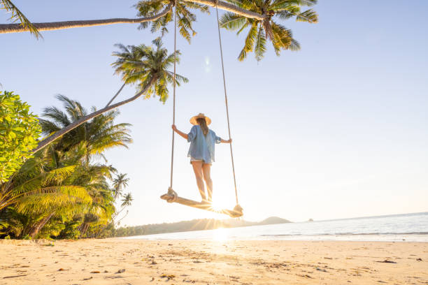 istock Woman on Swing at Tropical Beach During Sunset 2192870957