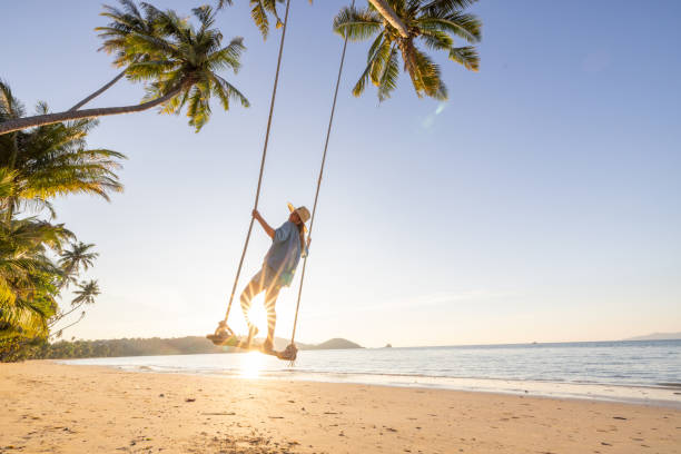 istock Woman on Swing at Tropical Beach During Sunset 2192870964
