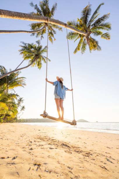 istock Woman on Swing at Tropical Beach During Sunset 2192870967