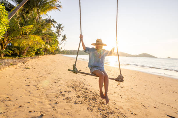 istock Woman Relaxing on a Beach Swing at Sunset 2192871058
