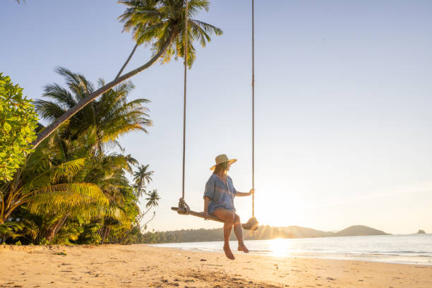 istock Woman Relaxing on a Beach Swing at Sunset 2192871210