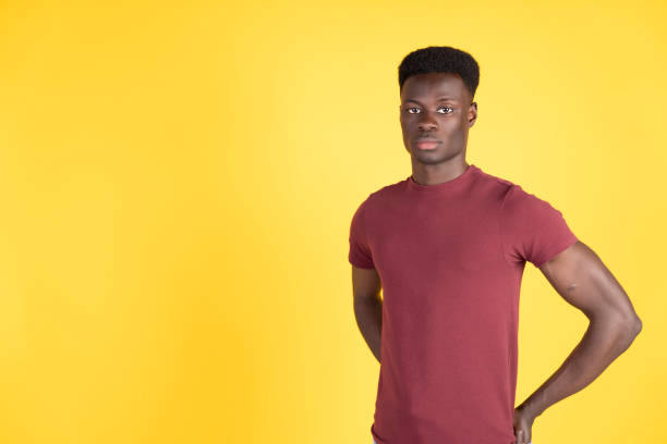 istock Young man posing with hands on hips on yellow background 2192871219