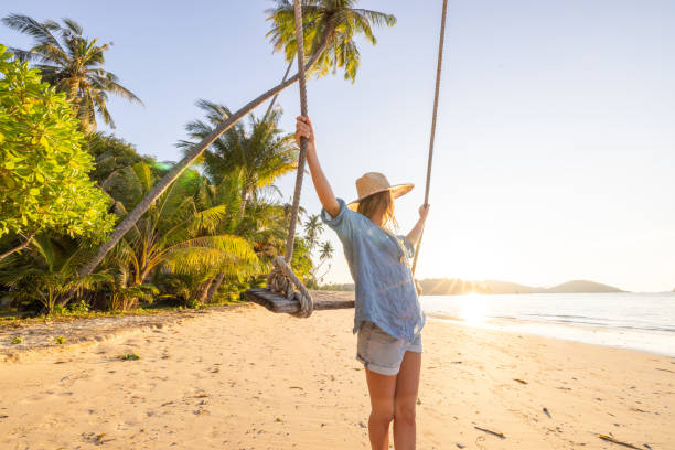 istock Woman Enjoying a Swing on a Tropical Beach at Sunset 2192871273