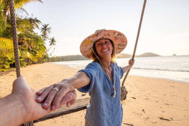 istock Woman on Beach Swing Holding Hands with Partner 2192871311