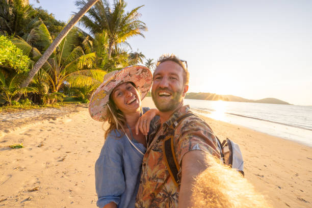 istock Couple Taking Selfie Under Palm Trees in Tropical Setting 2192871553