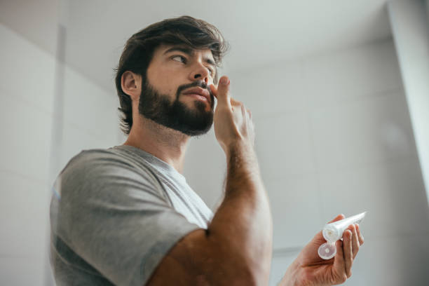 istock Low angle shot of a bearded man putting on on facial moisturizer 2192871777