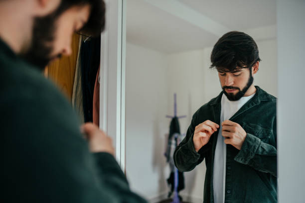 istock Mirror view of a man buttoning his shirt 2192871795