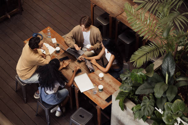 istock Four Friends Collaborating at a Cafe During a Friendly Team Meeting 2192873679