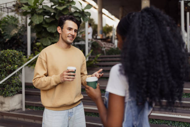 istock Young Friends Enjoy Casual Conversation Over Coffee Outdoors in a Relaxed Setting 2192873687