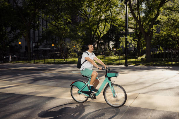 istock Man Riding Bicycle Through Urban Park During a Sunny Afternoon 2192876453